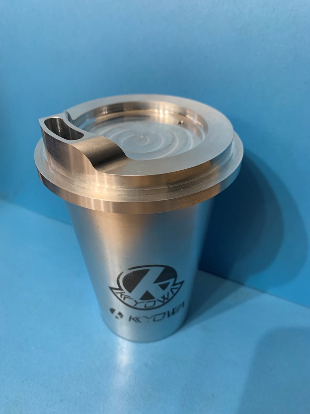 同じコーヒーカップを別角度から見た様子。蓋の飲み口の形状が見える。