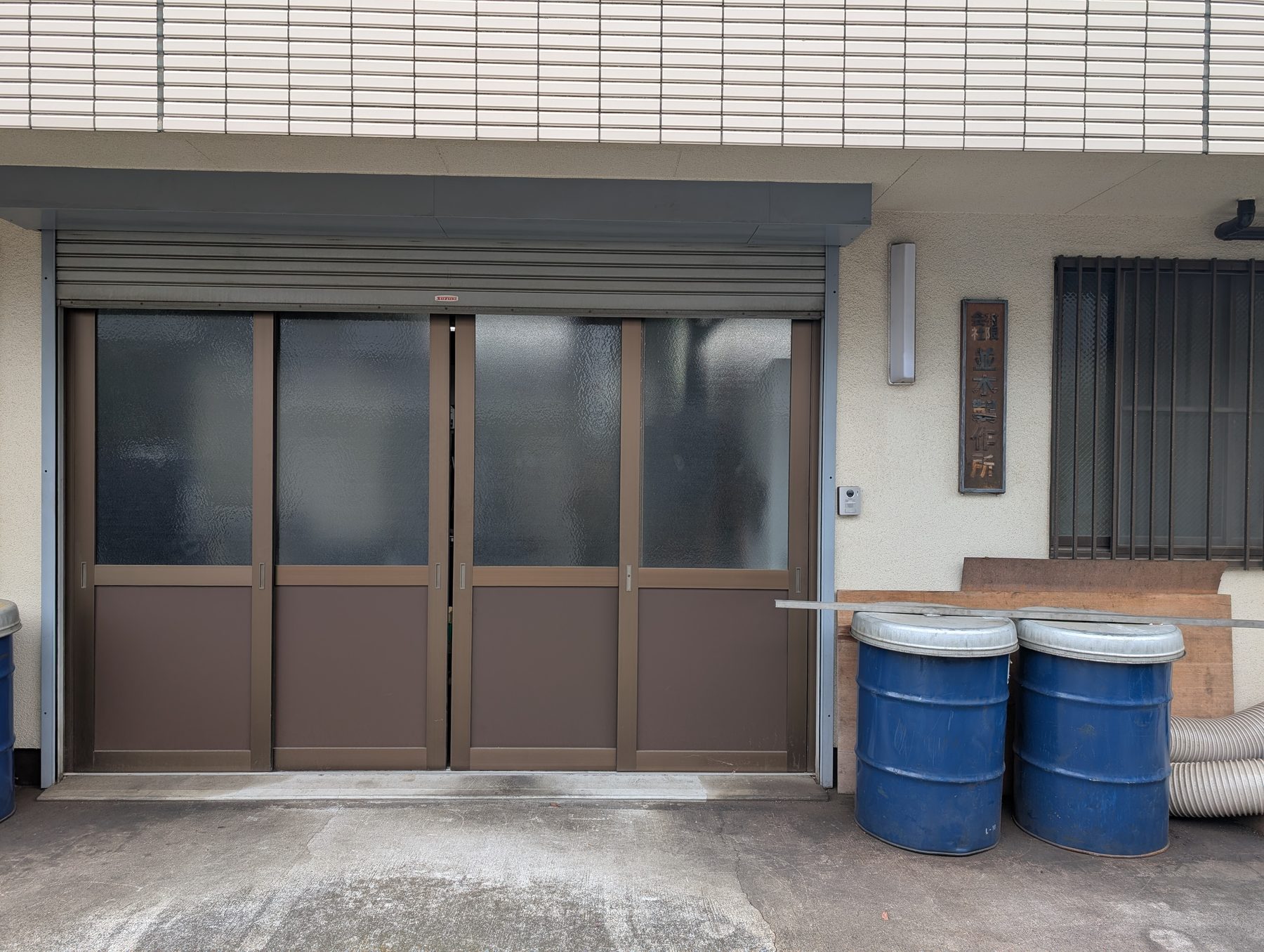 有限会社 並木製作所の工場入口。木の看板と引き戸。